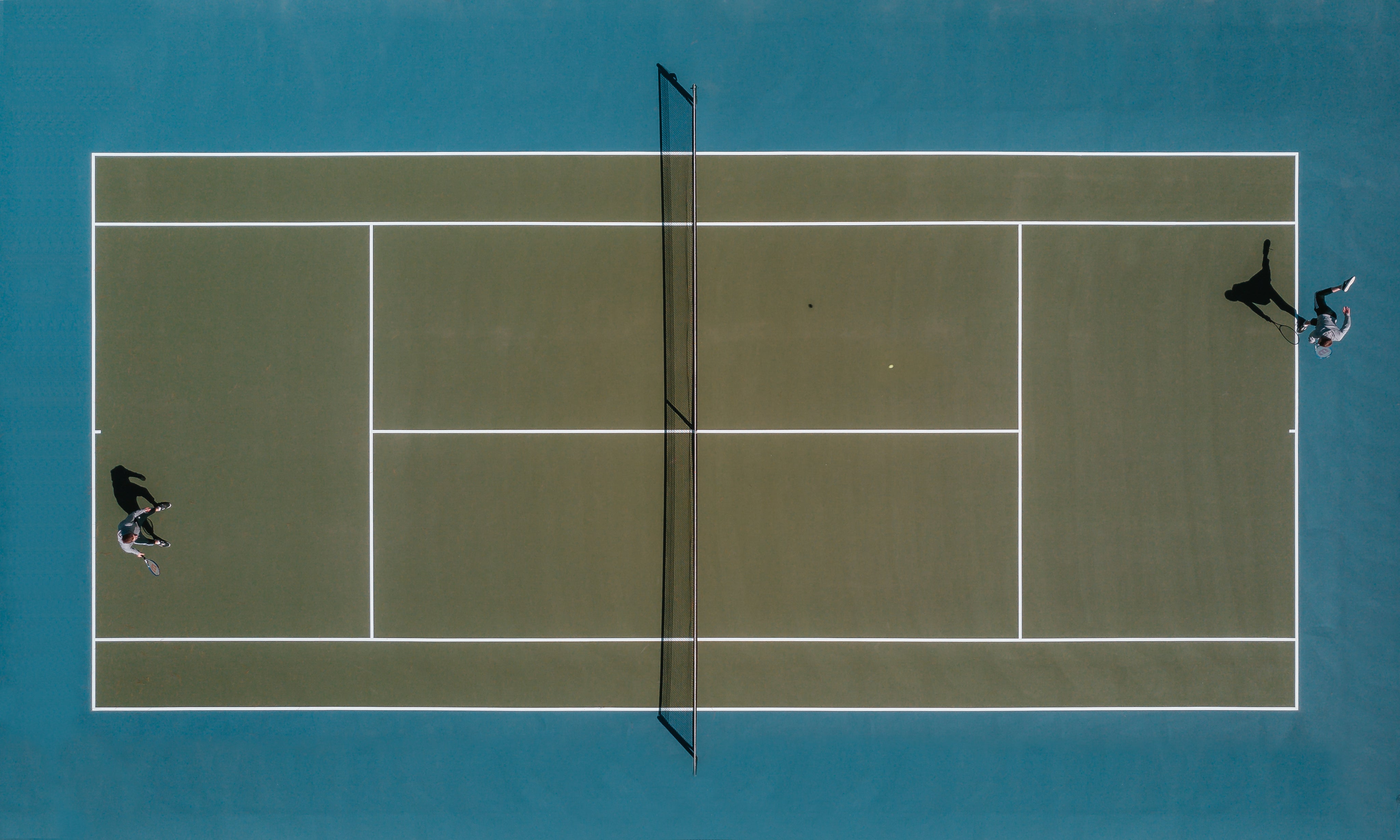 aerial-view-of-two-people-playing-tennis-in-the-sun.jpg