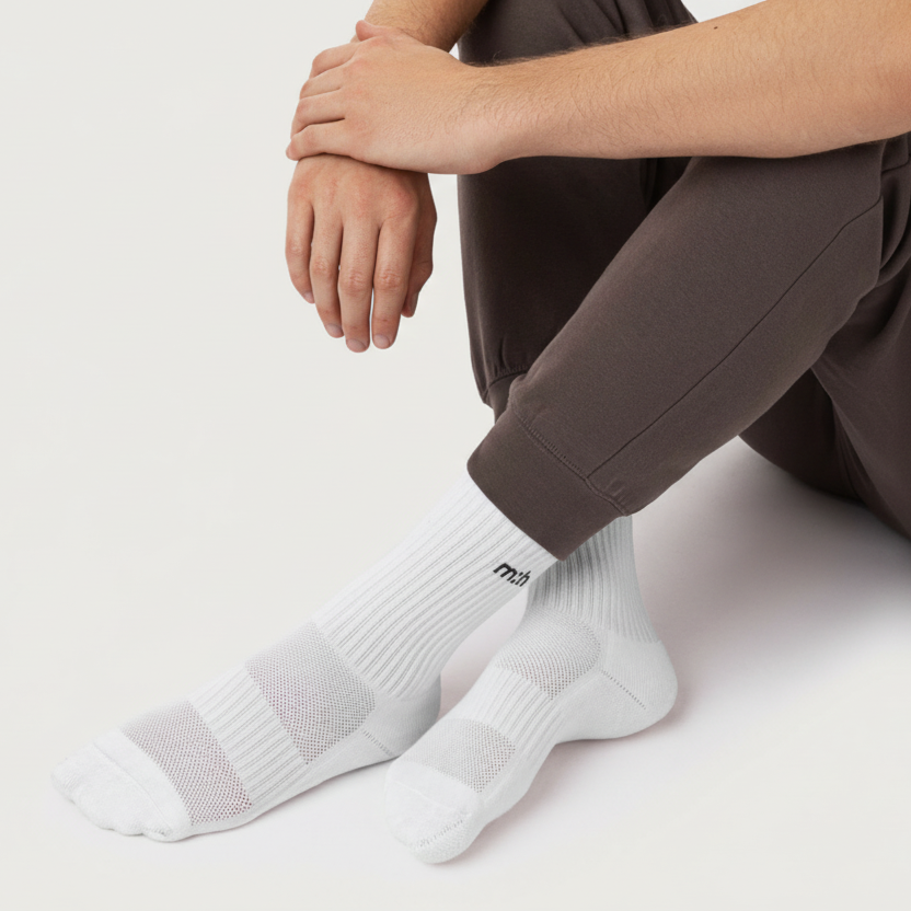 Person wearing white socks with a brand logo on a light background